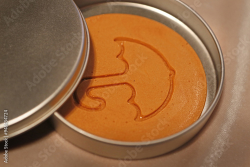 Close-up of red Dalgona snack with umbrella shape in a metal can near Samcheok-si, South Korea  photo