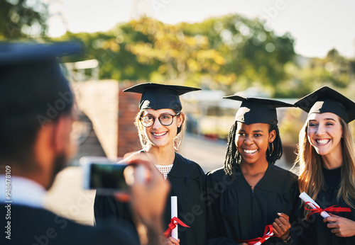 Phone, students and graduation picture in outdoor, diploma celebration and photography memory. People, friends and certified together for university success, social media post and women for victory