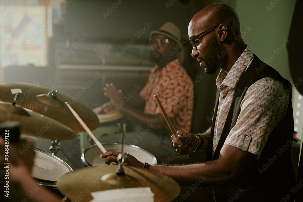 Φωτογραφία Side view shot of young Black man playing drums in modern jazz music band, copy