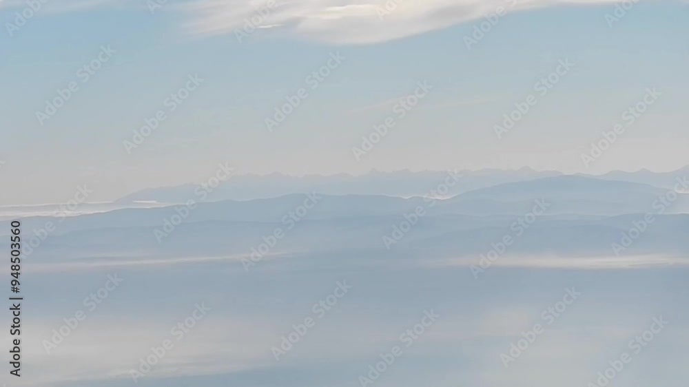 Aerial misty view over land with Tatra Mountains in fog and horizont with blue sky and whitye clouds. Topics: Tatras, Europe, weather, meteorology, space, atmosphere, air travel Aerial misty view over land with Tatra Mountains in fog and horizont with blue sky and whitye clouds. Topics: Tatras, Europe, weather, meteorology, space, atmosphere, air travel