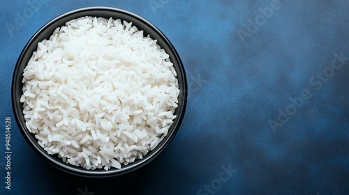 A bowl of freshly cooked white rice on a blue background.