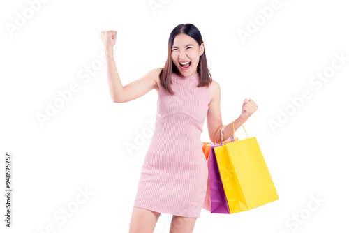 Joyful woman celebrates while holding vibrant shopping bags against a matching pink background. The image captures the excitement and satisfaction of a successful shopping experience