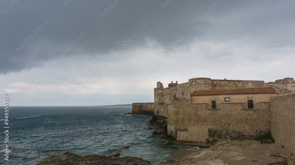 Ancient castle of Maniace at the coast on a cloudy rainy day, Syracuse, Sicily, Italy Ancient castle of Maniace at the coast on a cloudy rainy day, Syracuse, Sicily, Italy