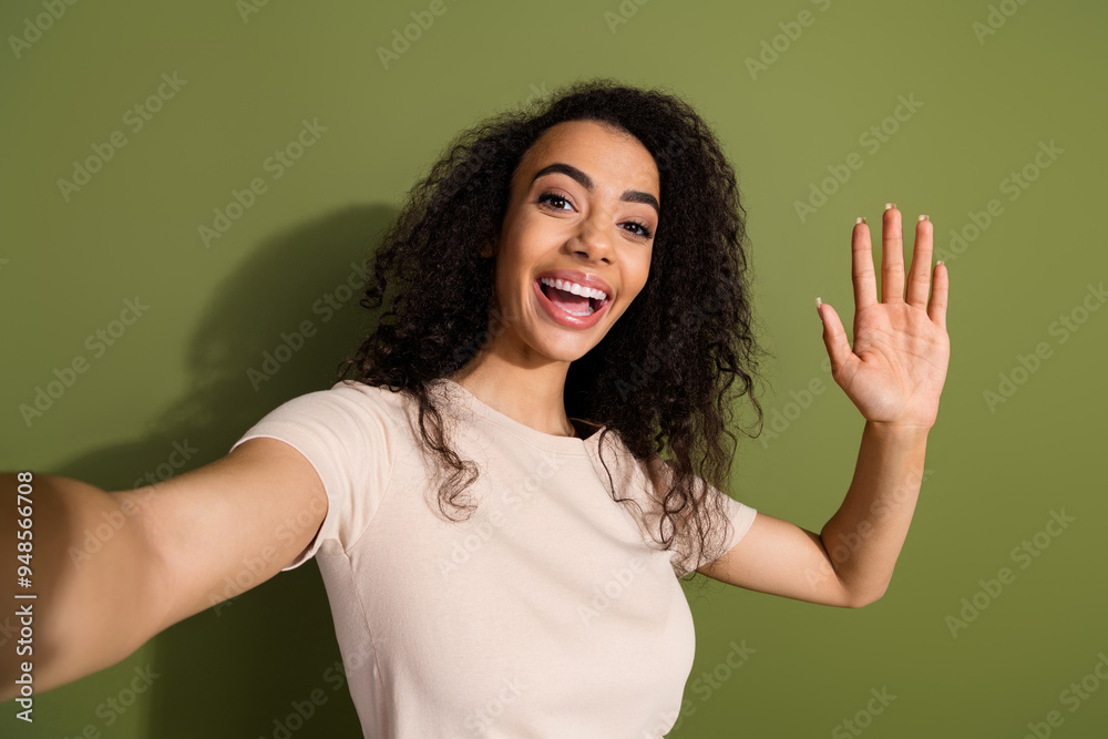 Photo of pretty adorable girl with wavy hairdo dressed beige t-shirt waving palm say hi making selfie isolated on khaki color background Photo of pretty adorable girl with wavy hairdo dressed beige t-shirt waving palm say hi making selfie isolated on khaki color background