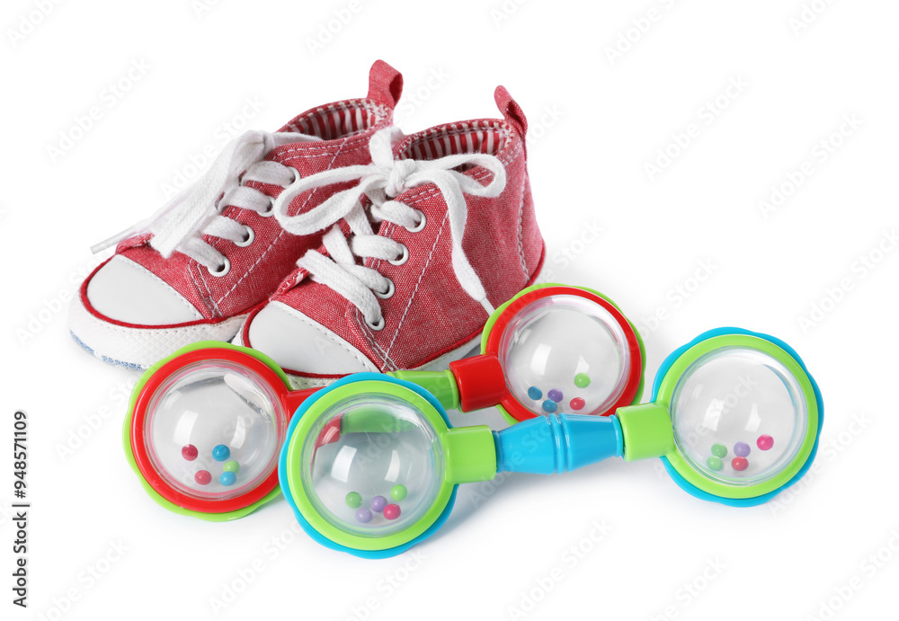 Colorful rattle and baby shoes isolated on white Colorful rattle and baby shoes isolated on white