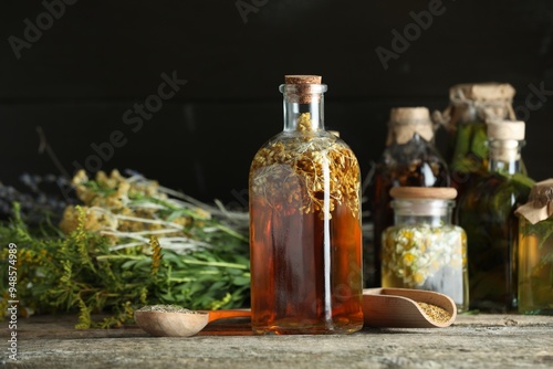 Different tinctures in bottles and herbs on wooden table