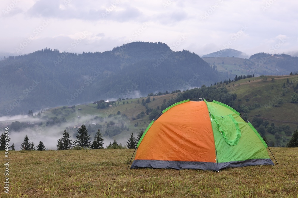 Tent on green grass in mountains, space for text Tent on green grass in mountains, space for text