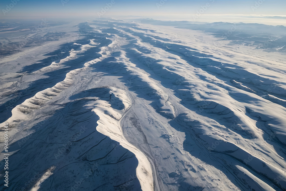 Fototapeta premium a aerial view photo of a smooth, snow-covered plain, with soft undulations providing a clean and peaceful backdrop