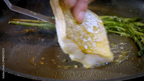 White fish pike-perch, zander are fried in a pan in hot olive oil. The cook flips the white fish fillet over to the other side. 4k slow motion 100 fps footage.