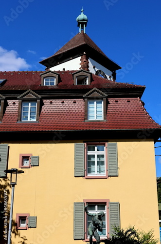 Spitze des Schwabentors in Freiburger hinter einem gelben Altbau photo