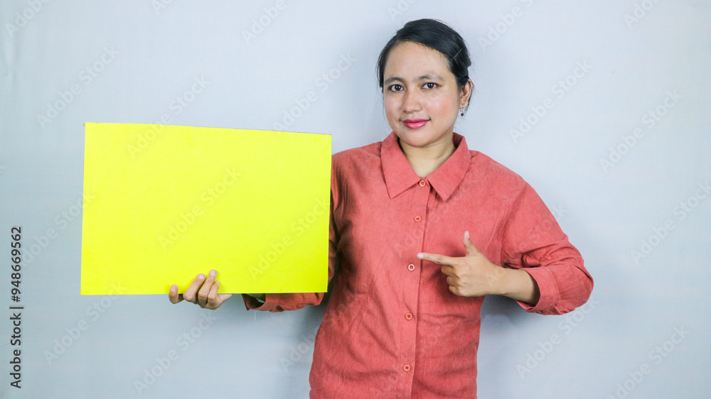 beautiful asian woman hold a blank yellow sheet in his hands. Place for text. beautiful asian woman hold a blank yellow sheet in his hands. Place for text.