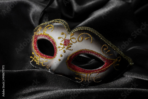 One beautiful carnival mask on black fabric