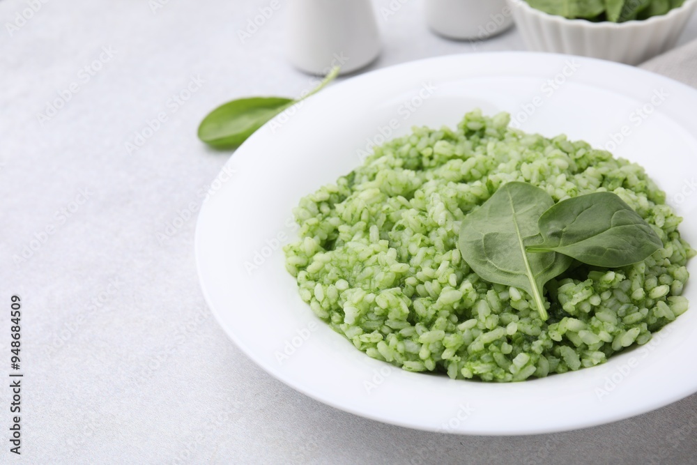 Delicious spinach risotto on light grey table, closeup Delicious spinach risotto on light grey table, closeup