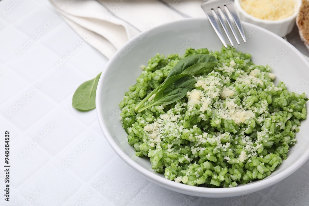 Delicious spinach risotto with parmesan cheese served on white tiled table, closeup. Space for text Delicious spinach risotto with parmesan cheese served on white tiled table, closeup. Space for text