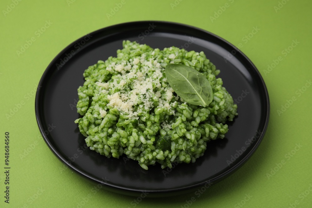 Delicious spinach risotto with parmesan cheese on light green background Delicious spinach risotto with parmesan cheese on light green background