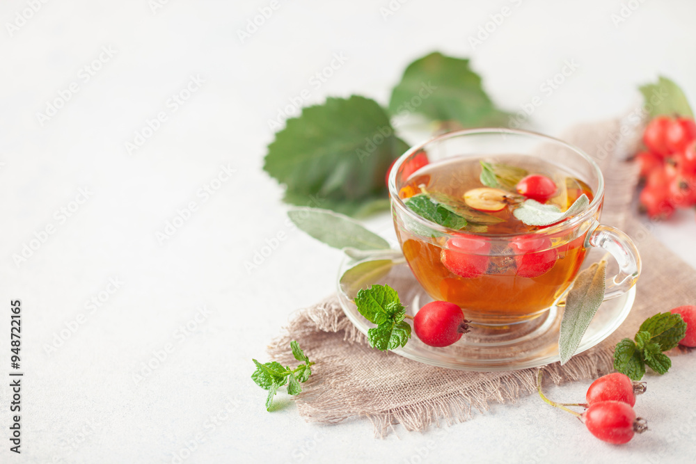 Hawthorn tea with mint and sage leaves in a glass cup on the table. Vitamin health drink. Copy space Hawthorn tea with mint and sage leaves in a glass cup on the table. Vitamin health drink. Copy space