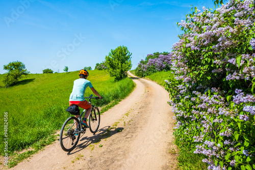 Obraz na płótnie Woman cyclist riding bicycle on gravel forest road, Wigry National Park, Podlasie, Poland w salonie