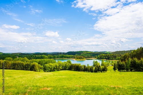 Obraz na płótnie View of Jaczno lake from hill with green meadow and trees, Suwalski Landscape Park, Podlasie, Poland w salonie