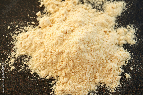 A heap of whey protein powder on dark background - nutritional supplement