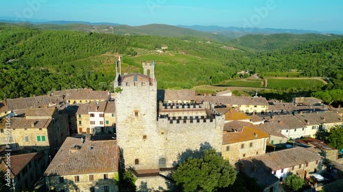 An aerial view of Castellina in Chianti, a picturesque town in Tuscany's renowned Chianti wine region, captured by a drone. Perched on a hill, Castellina in Chianti is surrounded by rolling vineyards 