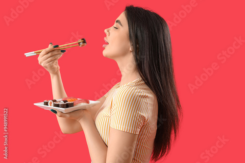 Young woman eating sushi ro...