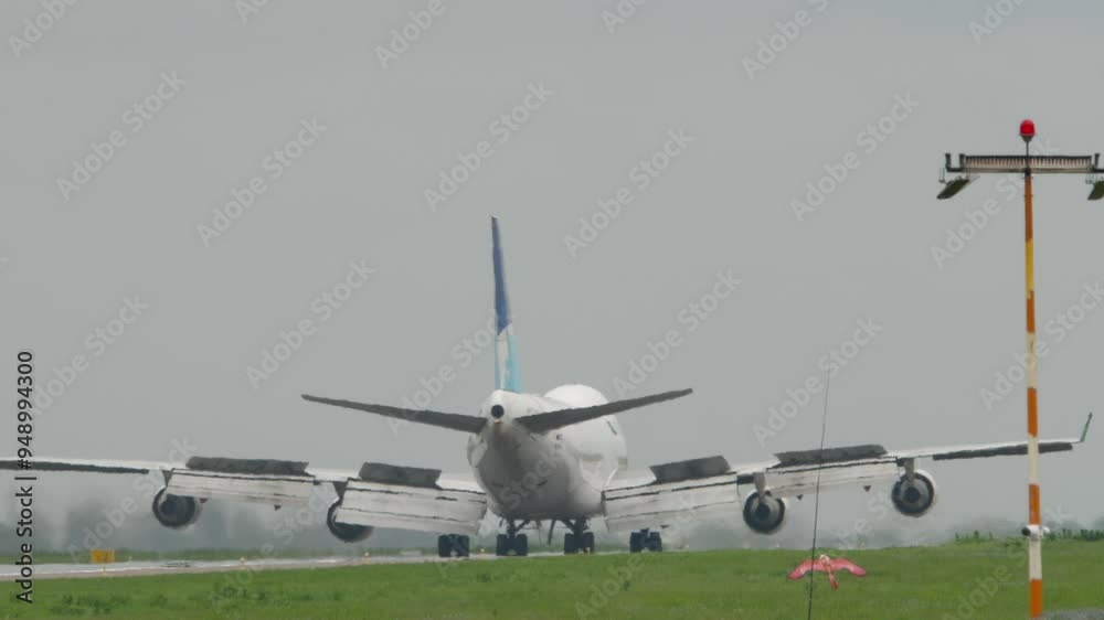 Wide body airplane braking after landing. Spoilers up. Airfreighter is arriving, rear view Wide body airplane braking after landing. Spoilers up. Airfreighter is arriving, rear view