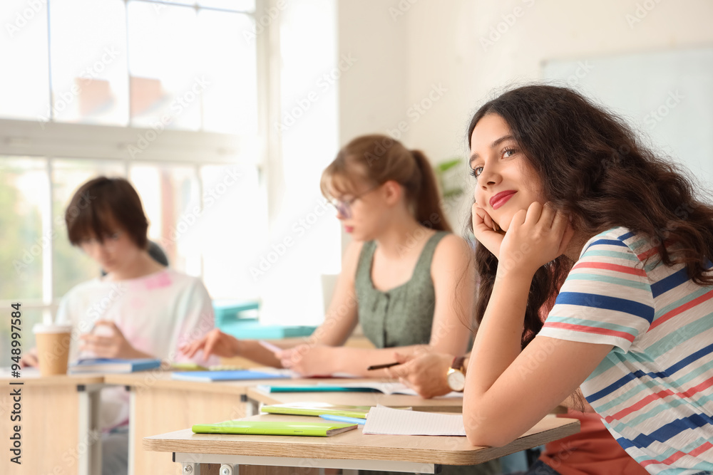 Female student with her classmates having lesson in classroom Female student with her classmates having lesson in classroom