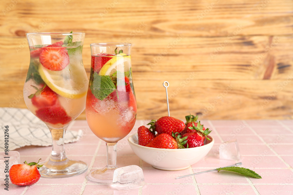 Glasses of fresh lemonade with strawberry and lemon on pink tile table Glasses of fresh lemonade with strawberry and lemon on pink tile table