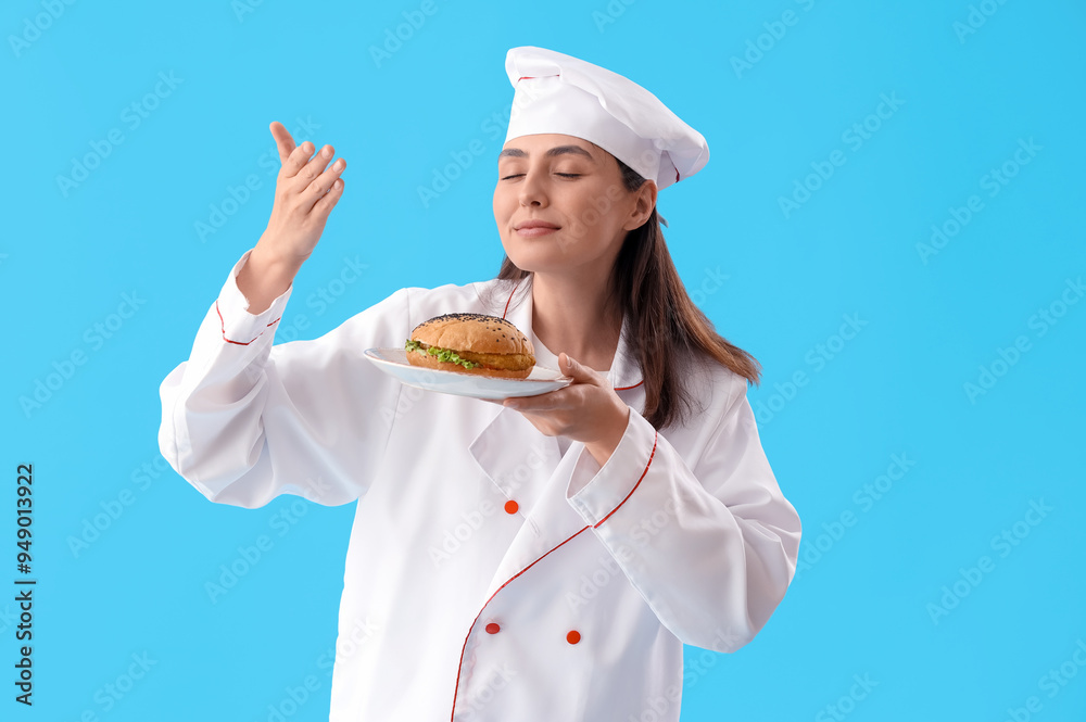 Female chef with tasty burger on blue background Female chef with tasty burger on blue background