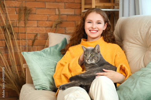 Young woman with cute cat lying on sofa at home