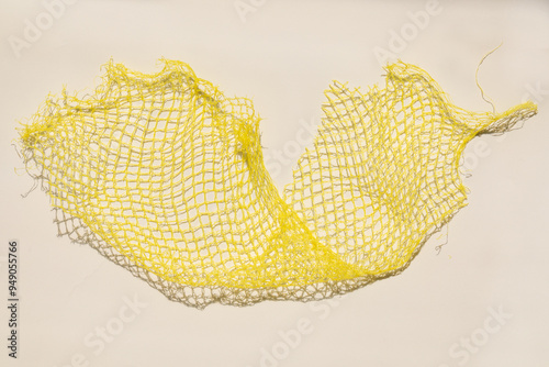 Fotografi yellow plastic produce mesh, fruit net, netting on white