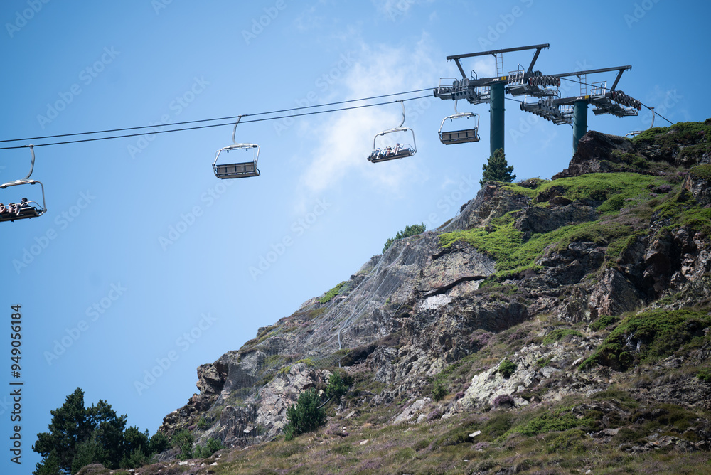 Ski lift ascending a rocky mountain under a clear sky Ski lift ascending a rocky mountain under a clear sky