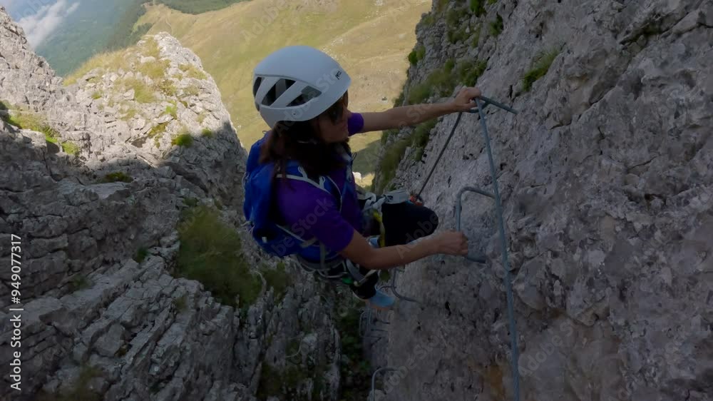 Female Rock Climber Climbing A Rock Wall Via Ferrata Female Rock Climber Climbing A Rock Wall Via Ferrata