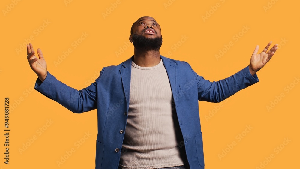 Cheerful pious african american man looking up to sky, waiting for sign from his god. Happy spiritual man doing worship hand gesturing, hoping for miracle, isolated over studio background, camera B Cheerful pious african american man looking up to sky, waiting for sign from his god. Happy spiritual man doing worship hand gesturing, hoping for miracle, isolated over studio background, camera B