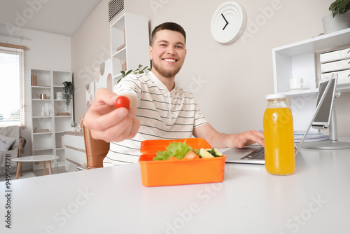 Young man with laptop takin...