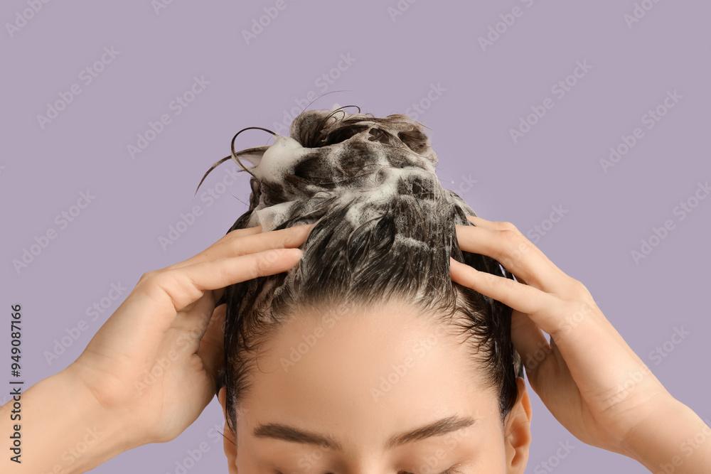 Fototapeta premium Beautiful young woman washing her hair with shampoo on purple background, closeup