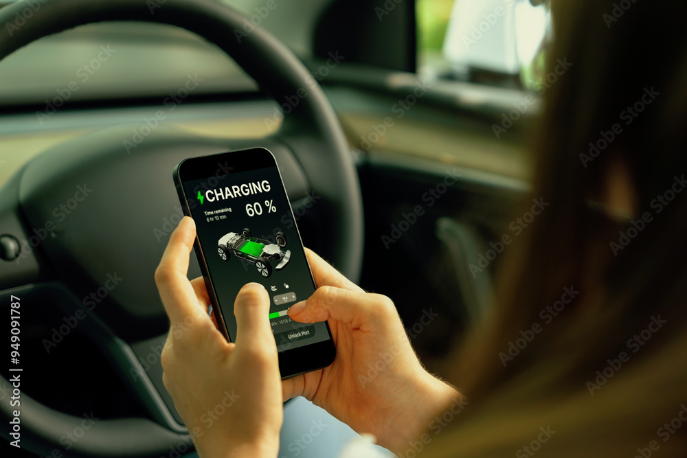 Φωτογραφία Young woman inside the vehicle, checking EV vehicle's application on battery recharging electricity status display on smartphone screen in modern EV car on her road trip journey