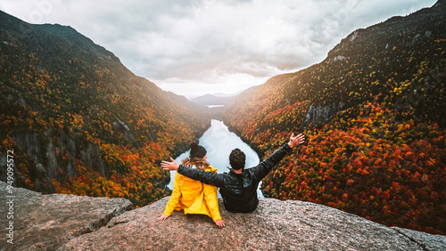 Fotografía Autumn Fall Foliage Indian Head Adirondacks Hiking Adventure Couple Sit Together, Arms Raised On Top of Mountain at Sunset