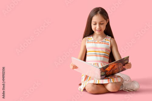 Cute little girl reading bo...