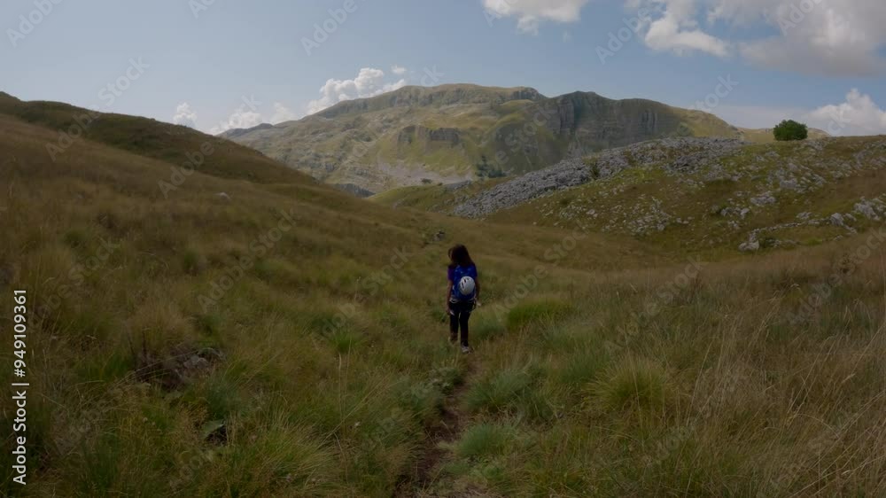 A female climber descends a hill after climbing A female climber descends a hill after climbing