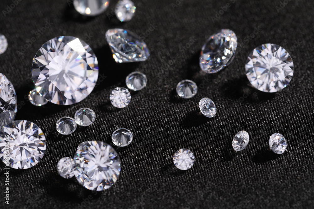 Many beautiful shiny diamonds on black fabric, closeup Many beautiful shiny diamonds on black fabric, closeup