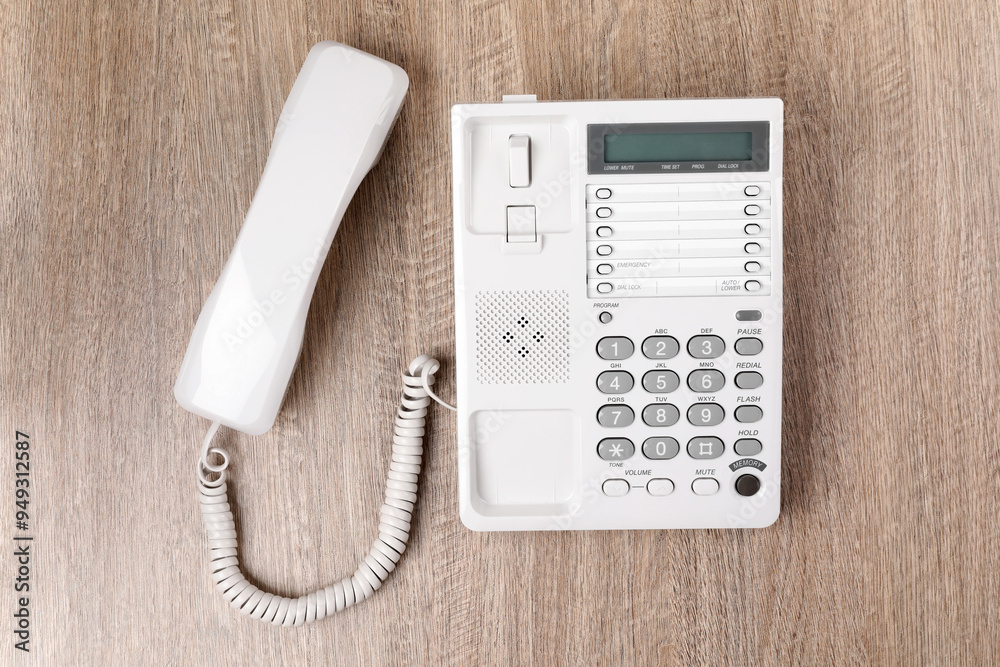 White telephone on wooden table, top view