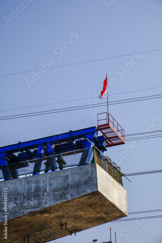 The Indonesian national flag flying over the toll road project building.