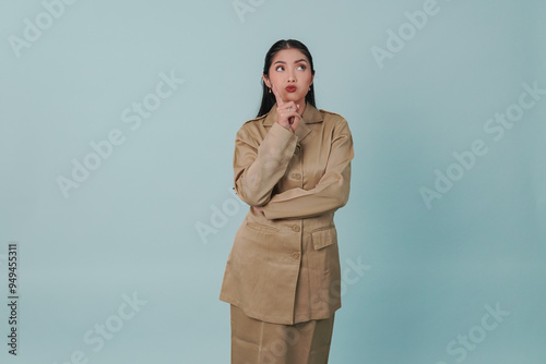 Serious Indonesian government worker woman doing thinking gestures while looking upward. photo