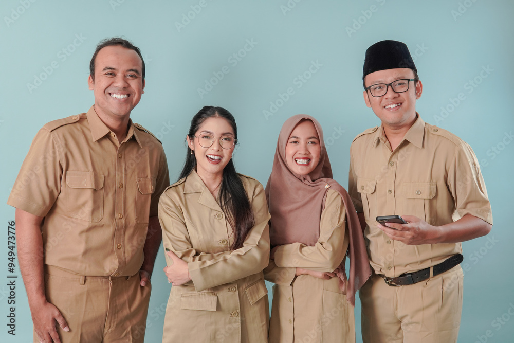 Fototapeta premium Four Indonesian government workers in khaki uniform posing and smiling to the camera.