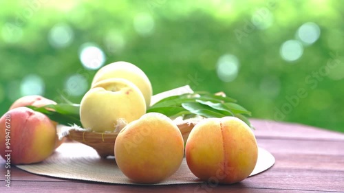 Fresh three kinds of peaches on blurred greenery background, Three colored peaches in basket on wooden table in garden.