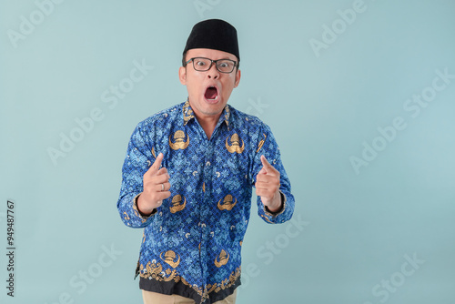 Stressful Indonesian government worker man wearing blue batik uniform going crazy. photo