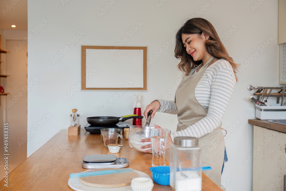 Focused Asian woman mixing ingredients for baking at home Focused Asian woman mixing ingredients for baking at home