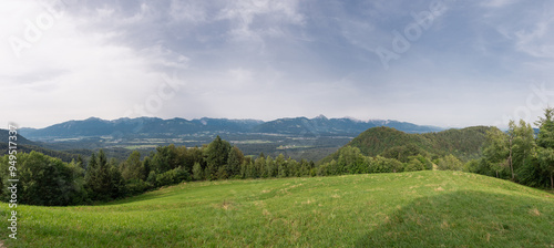 Obraz na płótnie Wide panorama of the karawanken alps from the magical Jamnik church above Kropa in Slovenia. Blue sky and green meadows and forests in front of picturesque mountains w salonie