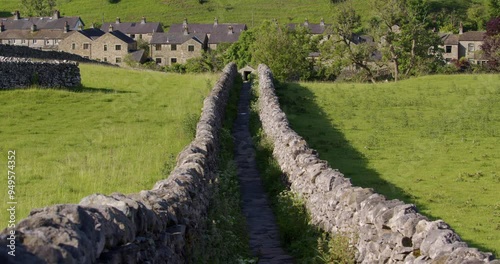 wide shot of a dry stone walled pathway leading down to Linton in background at the Yorkshire Dales photo